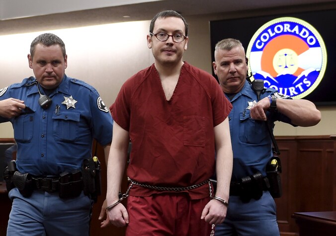 James Holmes wordt weggeleid.