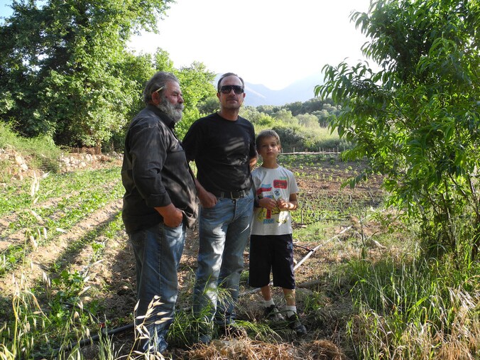 Stelios (71), zoon Nikos (45) en diens zoon Ilias (9) in hun pas aangelegde 'crisistuin'.