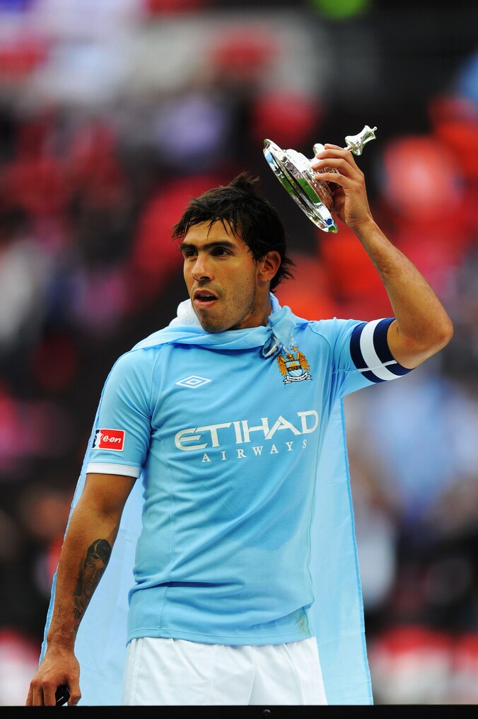 Carlos Tevez, die net als Vincent Kompany bij Manchester City speelt, dolde met de trofee toen zijn team die in 2011 in de wacht sleepte.