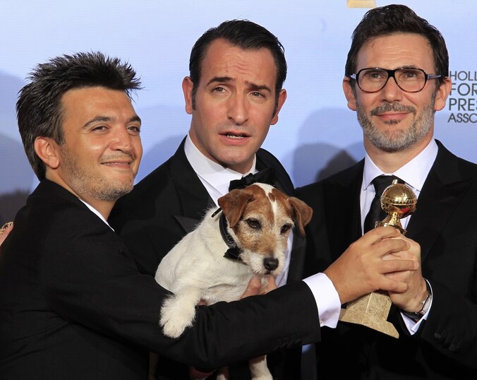 Producer Thomas Langmann (L), acteurJean Dujardin (C), regisseur Michel Hazanavicius én de hond Uggie poseren met hun Golden Globe.