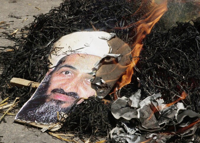 Een portret van Osama Bin Laden, brandend in de straten van New Dehli, India.