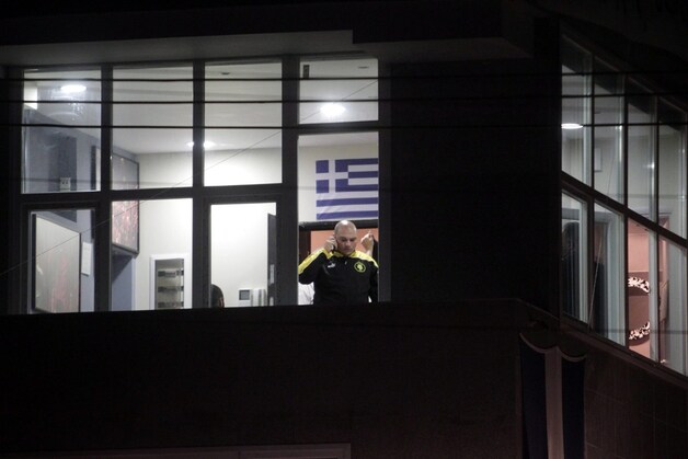 Parlementslid Giorgos Germenis van Gouden Dageraad telefoneert vanuit het lokaal waar de schietpartij gebeurde.