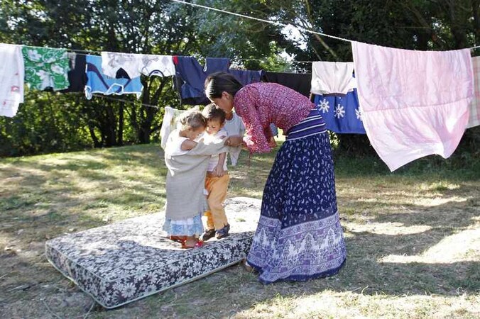 Een vrouw kleedt haar kinderen in een illegaal kamp in in Indre, bij Nantes.