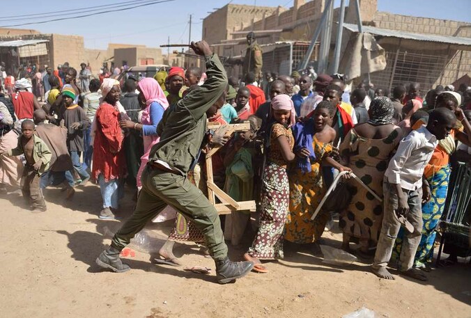 Malinese soldaten proberen plunderaars uit elkaar te drijven.