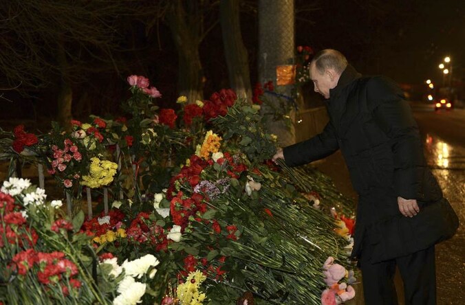 President Poetin legt een boeket rode rozen neer op de plaats waar maandag een aanslag werd gepleegd.