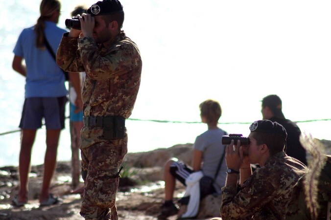 Italiaanse militairen op Lampedusa kijken uit over zee tijdens de reddings- en bergingsoperatie.