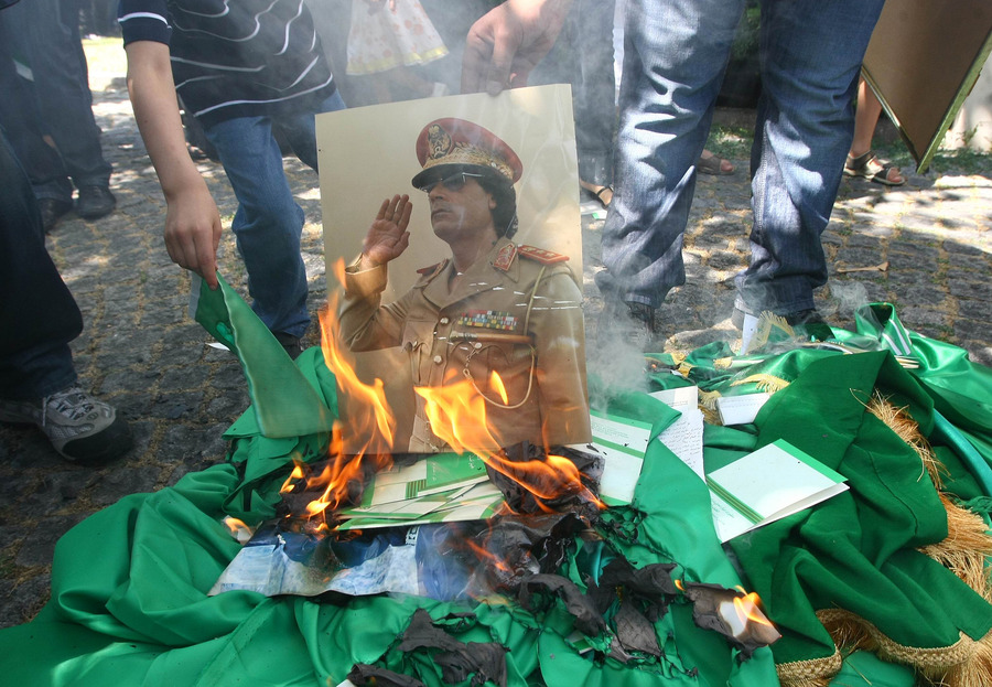 Opposanten verbranden een foto van Mouammar Kadhafi.