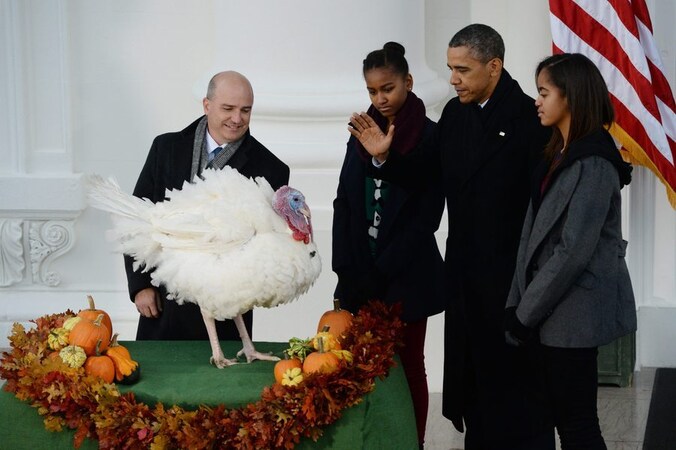 Obama, in gezelschap van zijn dochters Malia (R) en Sasha en de voorzitter van de Amerikaanse Kalkoen Federatie John Burke (L), verleent Popcorn gratie.