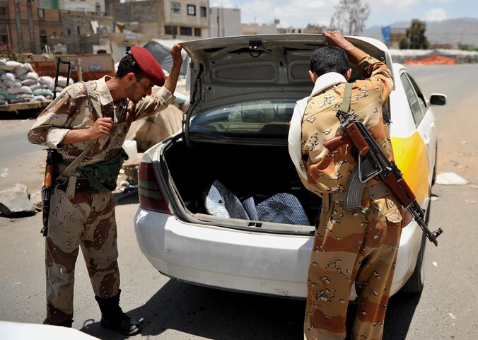 Twee Jemenitische soldaten controleren een voertuig in de hoofdstad Sanaa.