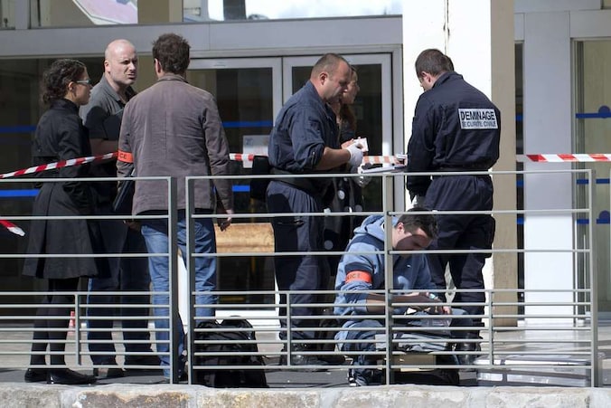 Politieagenten onderzoeken de plaats van de bomaanslag.