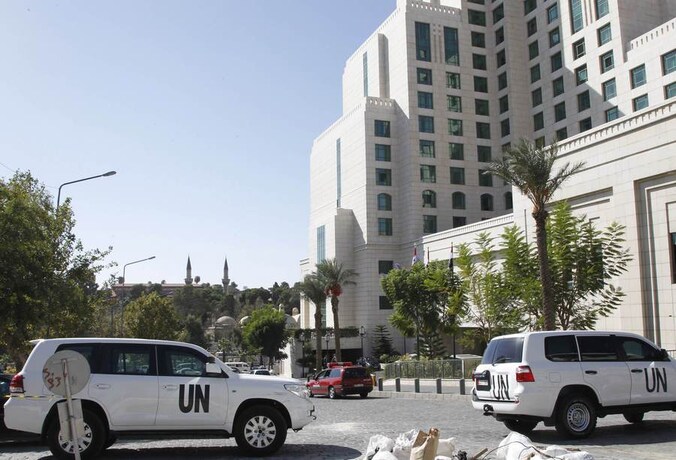 VN-wagens voor het Four Seasons-hotel in Damascus, waar een team van het OPCW toeziet op de vernietiging van het Syrische chemische wapenarsenaal.