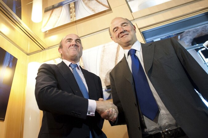 Pierre Moscovici (rechts) en Luis de Guindos (links).