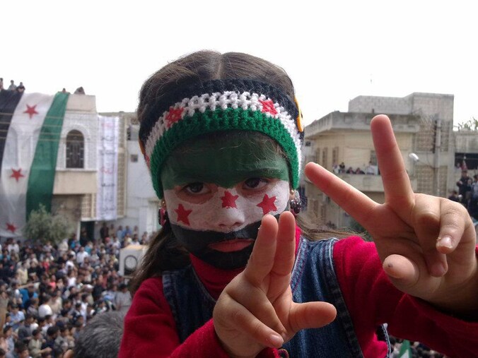 Een Syrisch meisje maakt het vredesteken tijdens een betoging tegen het regime in Talbisseh in de provincie Homs.