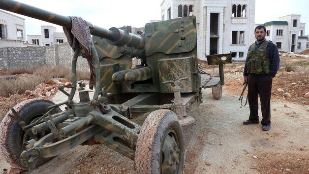 Rebellen bij het militair materieel dat ze hebben veroverd.