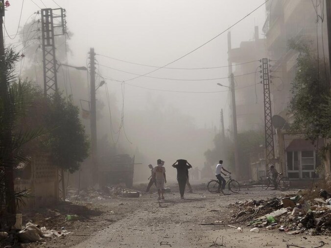 Bewoners van Deir Al-Zor inspecteren de schade na wat een aanval van Syrische troepen zou zijn geweest.