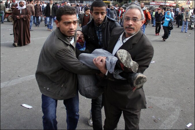 Een betoger wordt gewond weggedragen op het Tahrirplein.