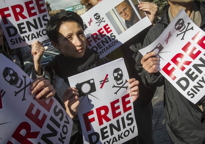 Demonstranten protesteren tegen de verlenging van de aanhouding van fotograaf Denis Snyakov, een van de bemanningsleden van het schip van Greenpeace.