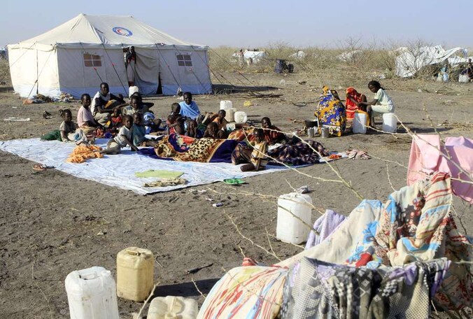 Zuid-Soedanese vluchtingen wachten op eten en drinken in een kamp van het Rode Kruis.
