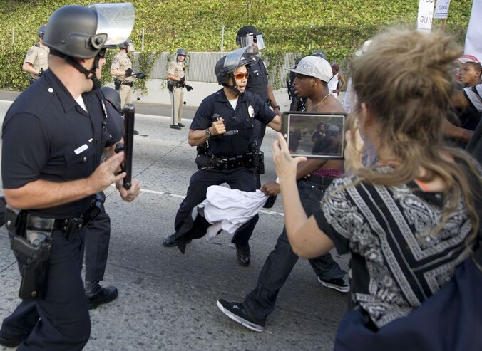 Politie in Los Angeles probeert bij snelweg 10 een aantal demonstranten tegen te houden.