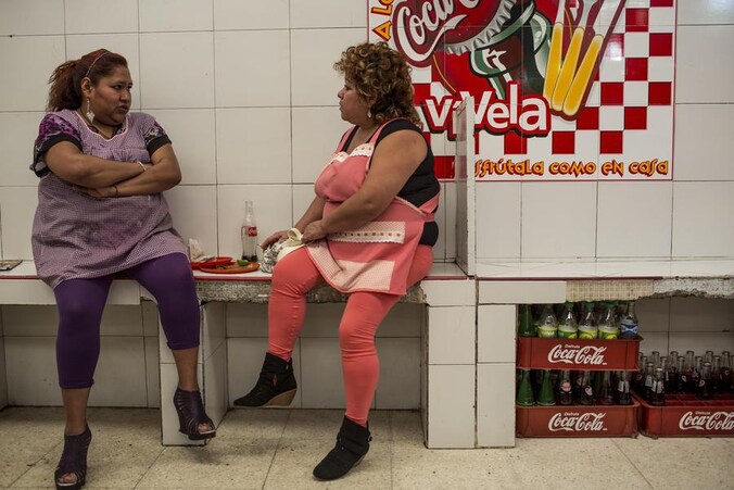 Mexicaanse vrouwen genieten van wat fastfood en frisdrank