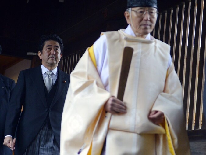 De Japanse premier Shinzo Abe (links) betreedt het Yasukuni-monument.