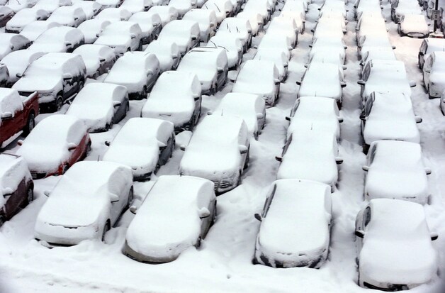 Geparkeerde wagens aan de internationale vlieghaven van Chicago, waar heel wat vluchten werden geannuleerd, raakten bedolven onder de sneeuw.