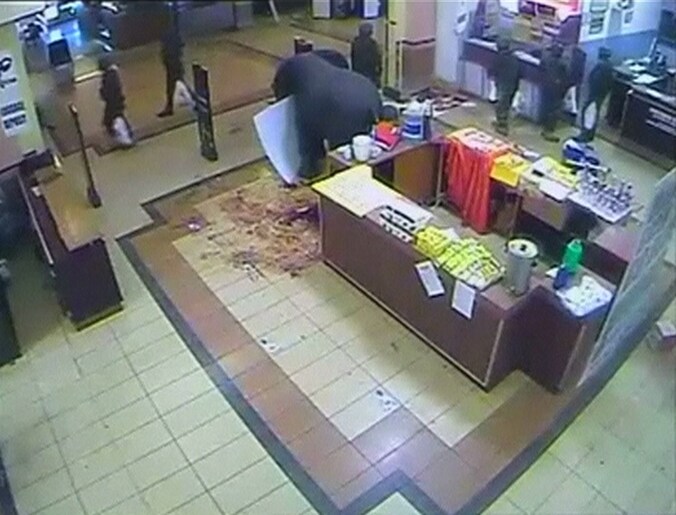 Militairen met plastic tassen verlaten de Nakumatt-supermarkt in het winkelcentrum Westgate in Nairobi kort na het begin van de aanval van terroristen.