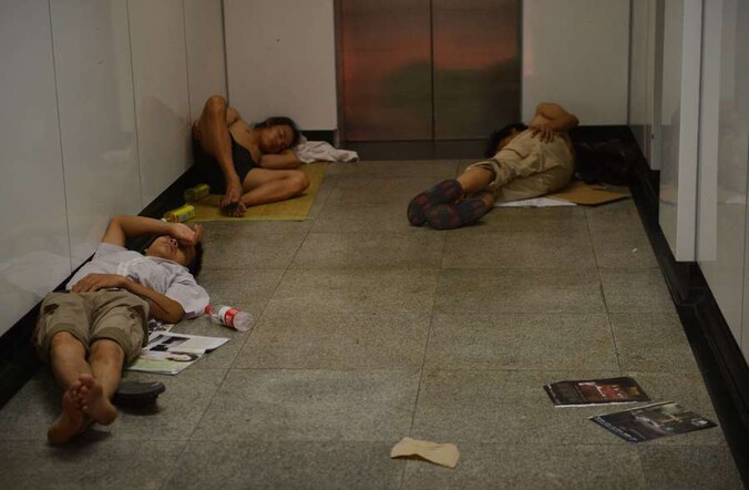 Chinezen zoeken afkoeling op de vloer van een metrostation in Shanghai.