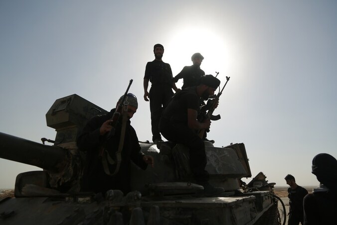 Syrische rebellen inspecteren een legertank in de stad Raqqah.