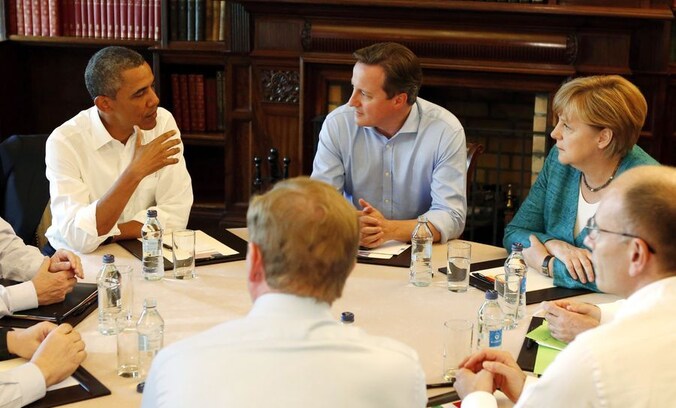 De Amerikaanse president Obama en de Duitse bondskanselier Merkel, gescheiden door de Britse premier Cameron, maandag tijdens de G8 in Enniskillen.