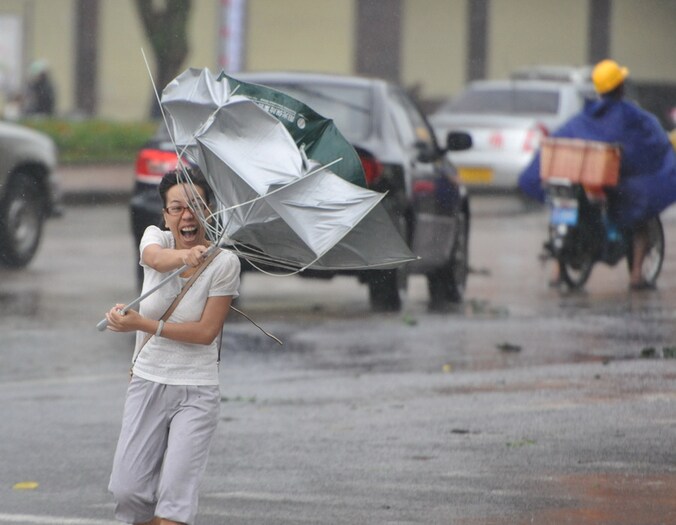 Een Chinese vecht tegen de wind in Qionghai.
