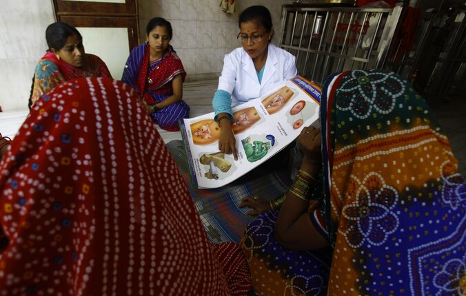 Een medewerkster van het Tata Memorial ziekenhuis in India legt enkele vrouwen het gevaar van baarmoederhalskanker uit.