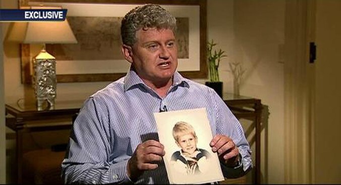 Lon Snowden houdt een afbeelding van zijn zoon omhoog.