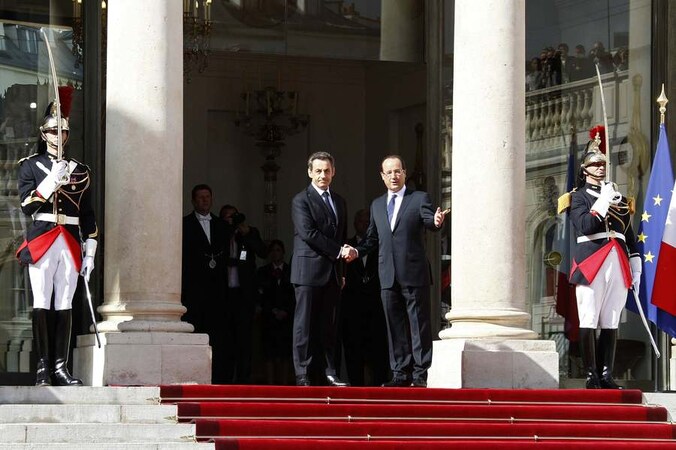 Uittredend president Nicolas Sarkozy schudt handjes met de nieuwe president François Hollande op de trappen van het Elysée, waar Hollande voortaan zal wonen.