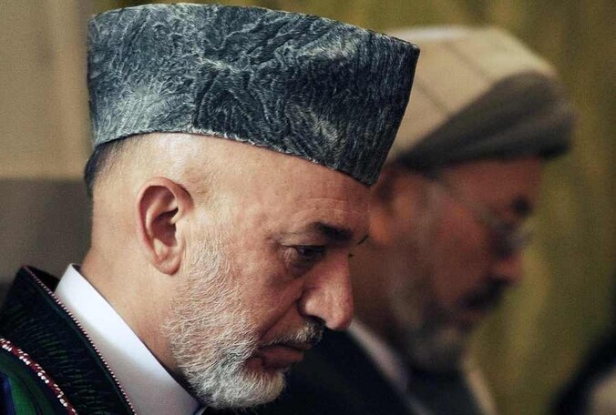Hamid Karzai op de begrafenis van zijn halfbroer.