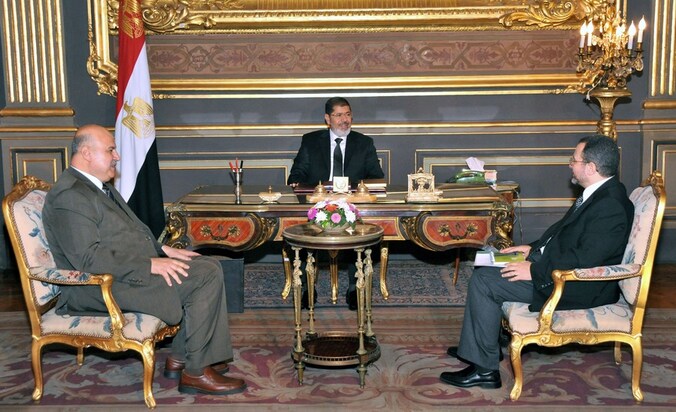 Archiefbeeld. Mohammed Mursi (midden) met ex-vicepresident Mukki (links) en premier Qandil (rechts)