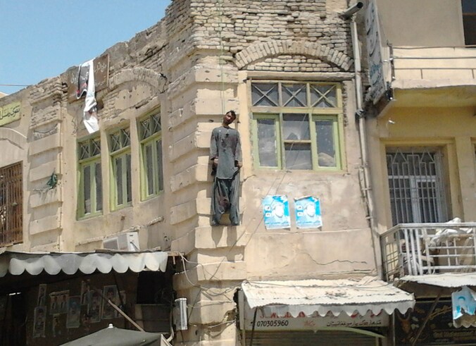 Moordenaar Sardar Mohammad wordt opgehangen aan een gebouw in Kandahar