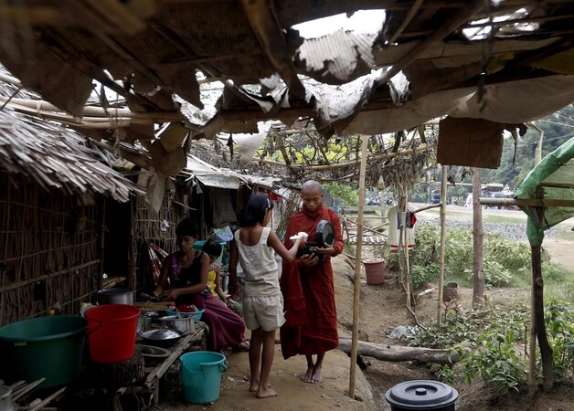 Een meisje in Rakhine dat een voedseloffer brengt aan een boeddhistische monnik