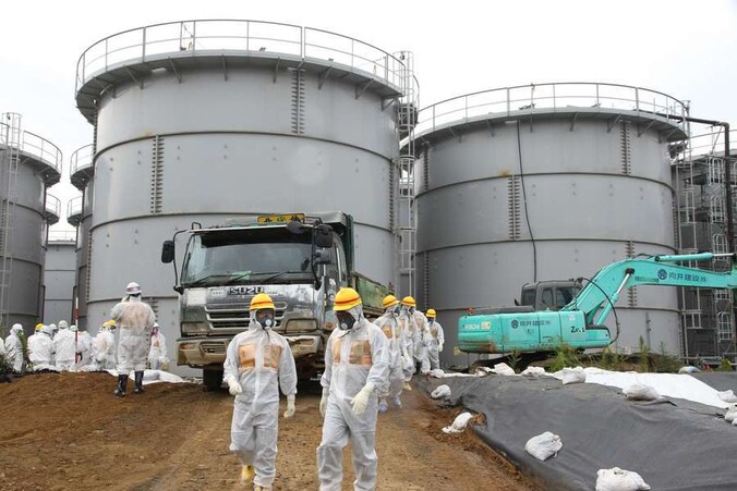 Inspecteurs en Tepco-medewerkers bij de opslagtanks van de centrale van Fukushima.