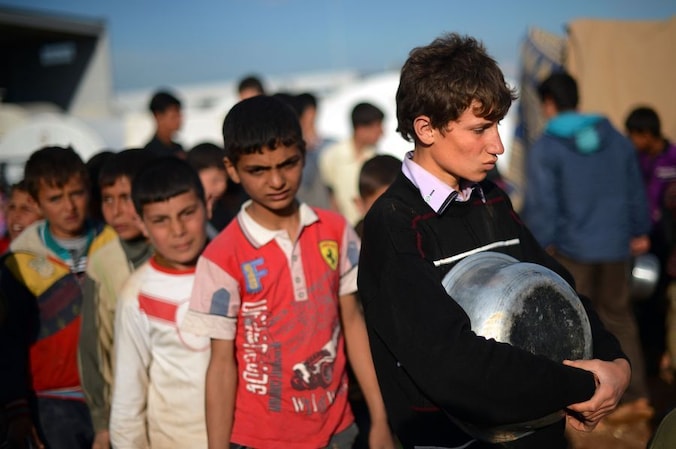 Syrische kinderen staan in de rij voor eten.