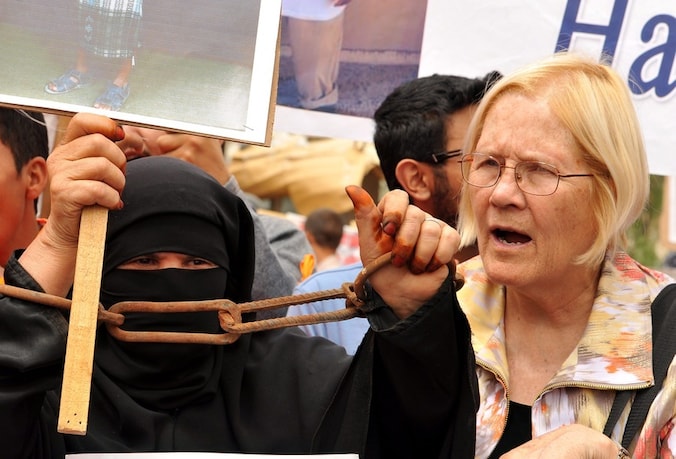 Een Amerikaanse activiste (rechts) voegt zich bij een betoging die maandag in Jemen werd gehouden voor de vrijlating van een aantal Jemenitische gevangenen in Guantánamo.