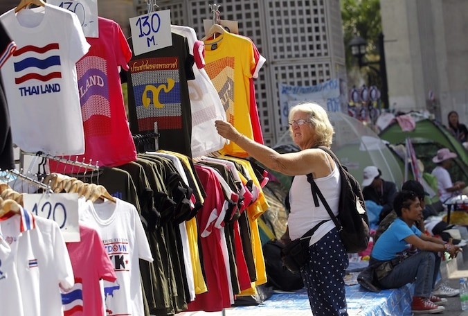 Een toerist bekijkt t-shirts met anti-regeringsslogans.