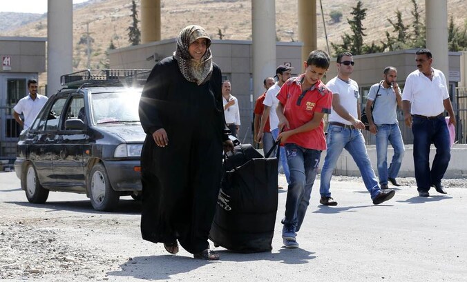 Syrische vluchtelingen steken de Turkse grens over.