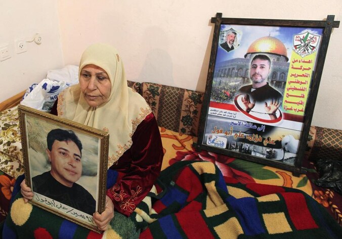De moeder van de Palestijnse gevangene Ali Abu Fool toont een foto van haar zoon die vanavond vrijgelaten wordt