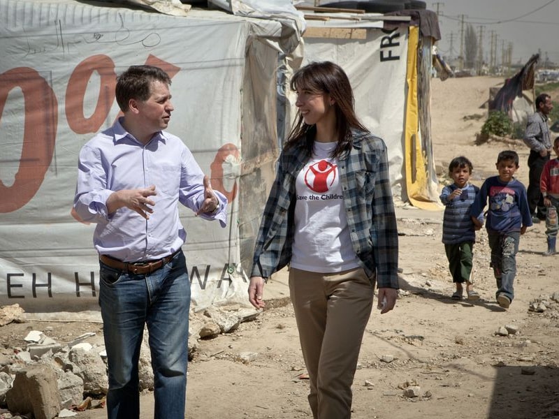De directeur van Save the Children loopt met ambassadeur Samantha Cameron door een vluchtelingenkamp in Libanon.