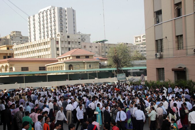 Kantoorwerknemers vluchten massaal de straat op in Pakistan na de aardbeving.