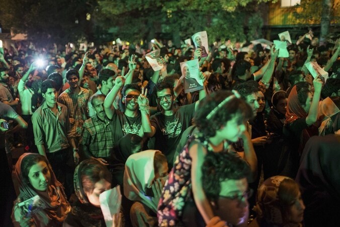 Aanhangers van Rohani vieren zijn overwinning op straat in Teheran, zaterdagavond.