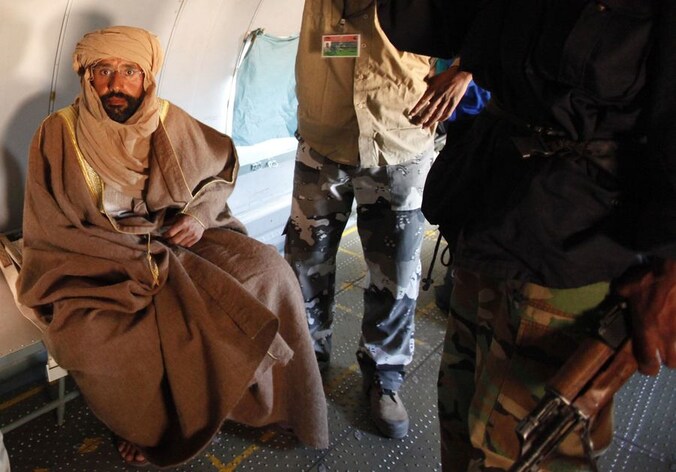 De gevangengenomen Saif al-Islam Kadhafi gefotografeerd in een vliegtuig nabij de stad Zintan. Hij deelde aan journalisten van het persagentschap Reuters mee in goede gezondheid te verkeren.
