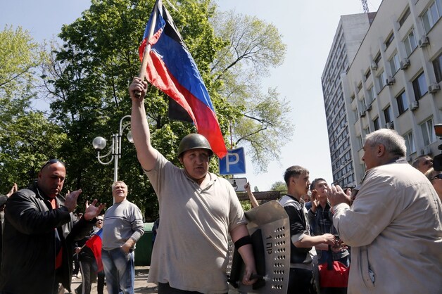Een man houdt de vlag omhoog van Volkskrepubliek Donetsk die deze week door pro-Russische separatisten is uitgeroepen.