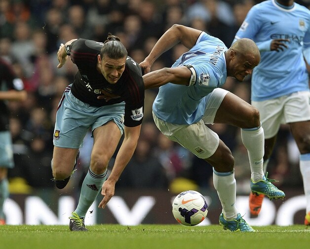 Kompany in een stevig duel met Andy Carroll.
